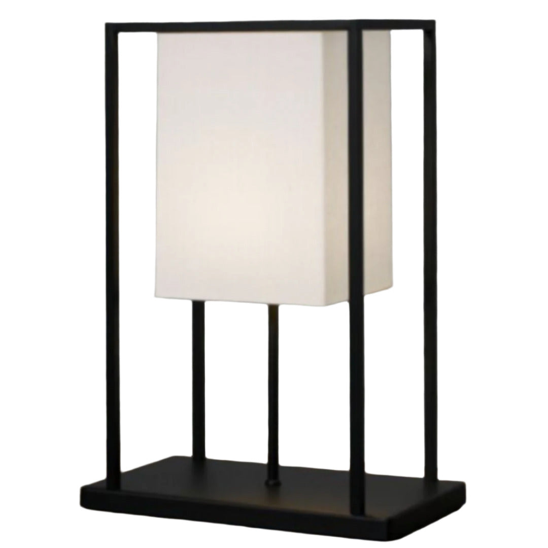 Table lamp with black frame and white shade on a textured surface