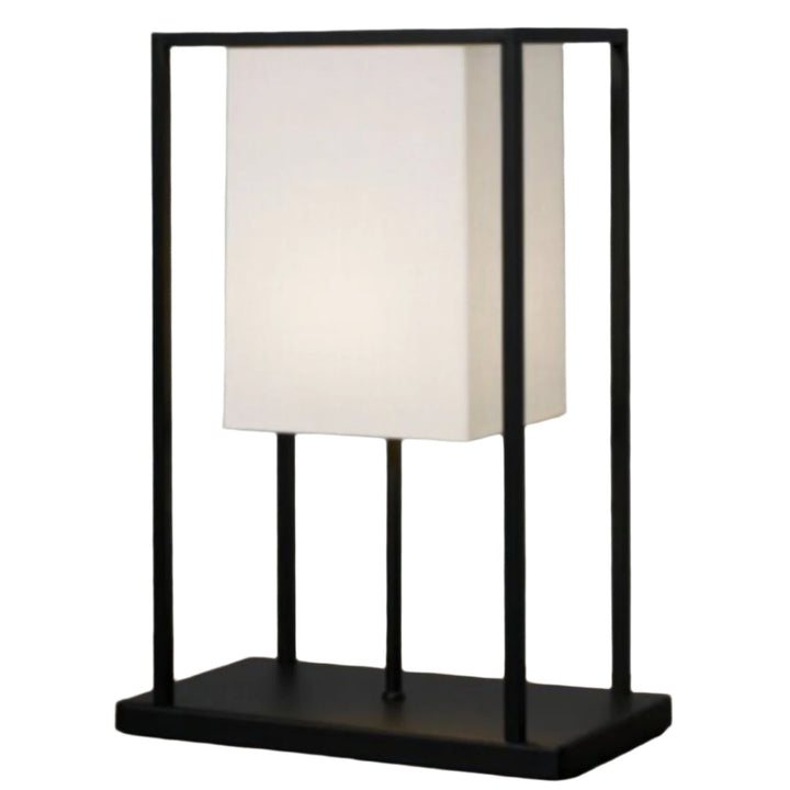 Table lamp with black frame and white shade on a textured surface