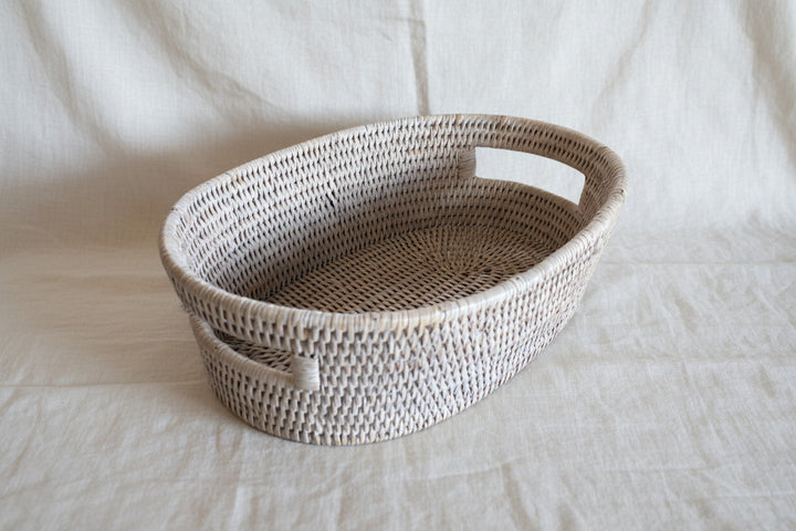 Woven basket with handles on a white background